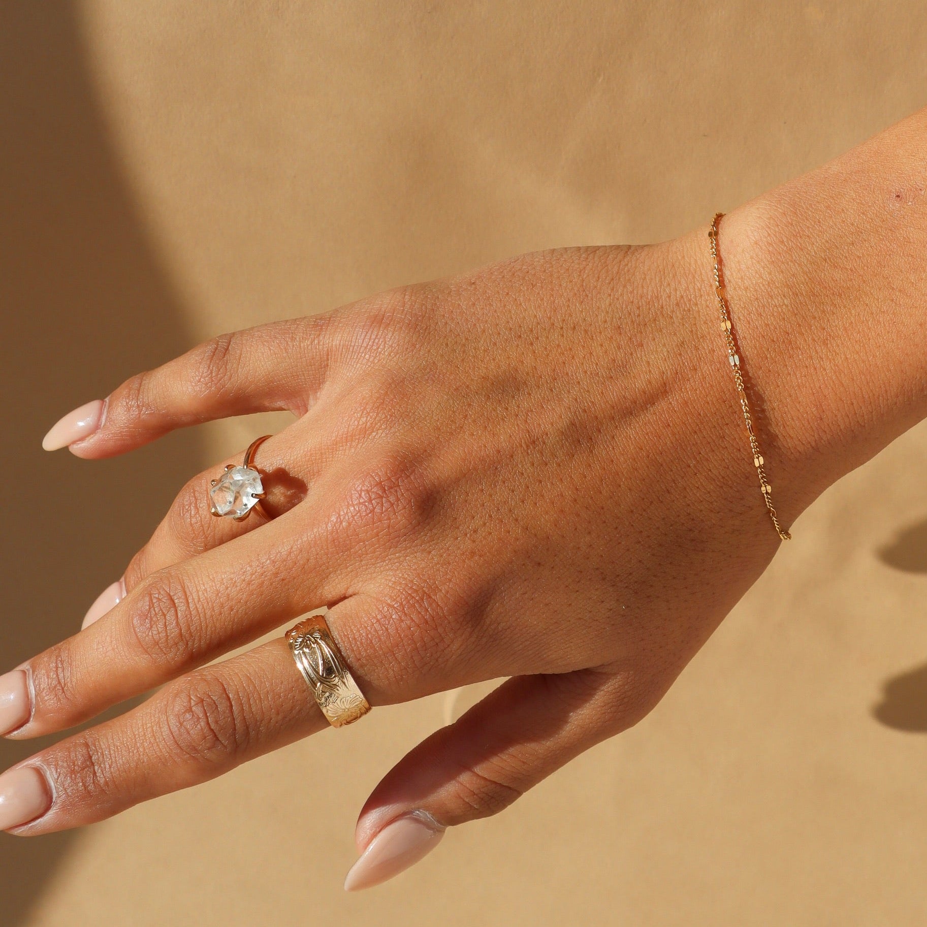 Gold sunburst chain bracelet with delicate textured links that catch the light.