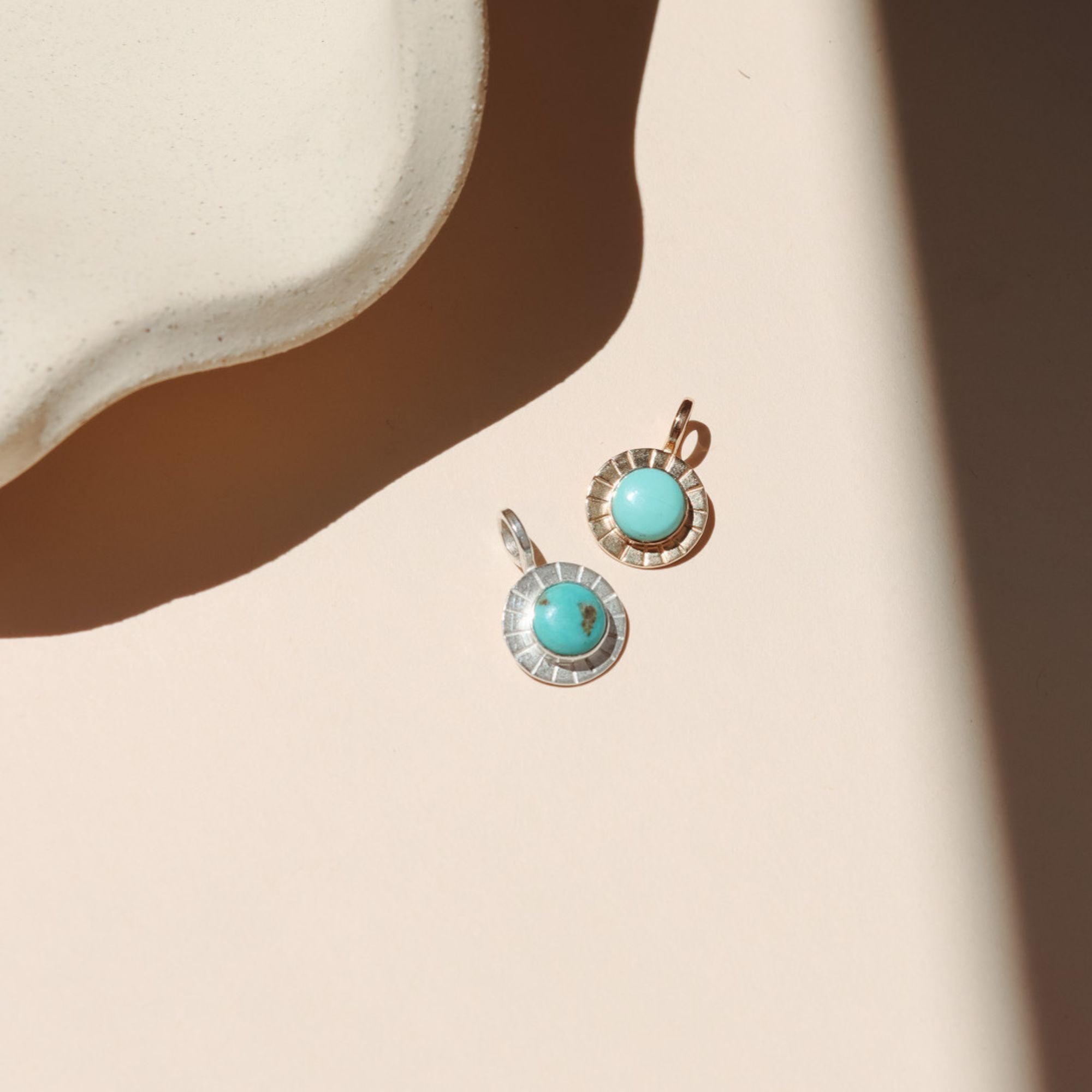 14k gold fill and sterling silver charms with round turquoise stones in the sunlight