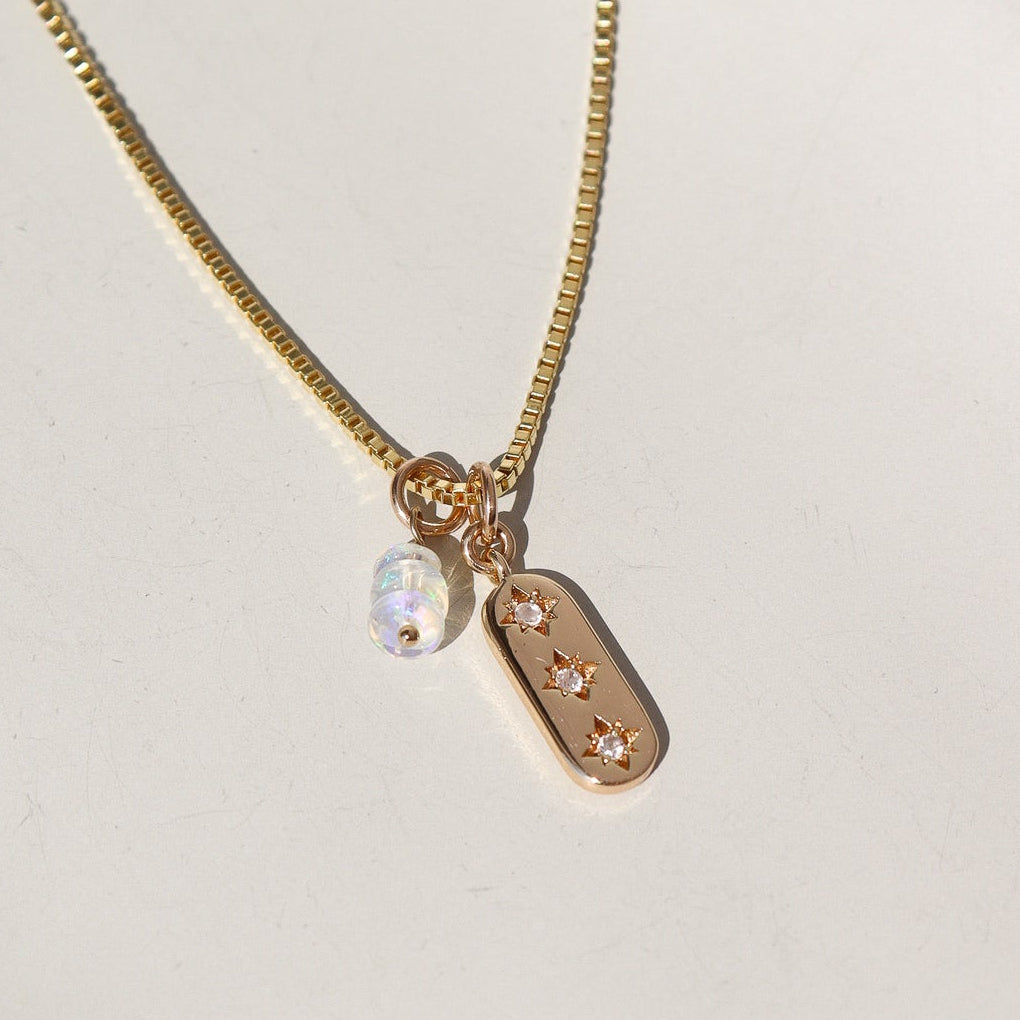 Gold necklace with a pendant on a white background