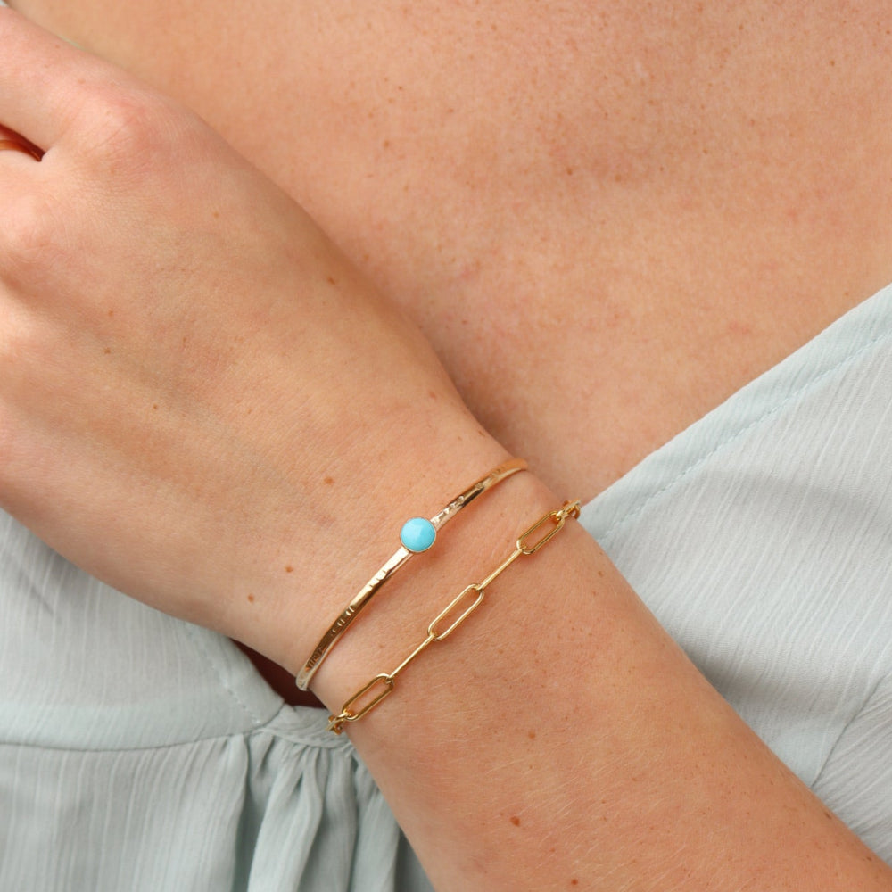 Model wearing Turquoise Skyline Cuff featuring a 6mm Sleeping Beauty turquoise cabochon on a hand-notched gold filled band.