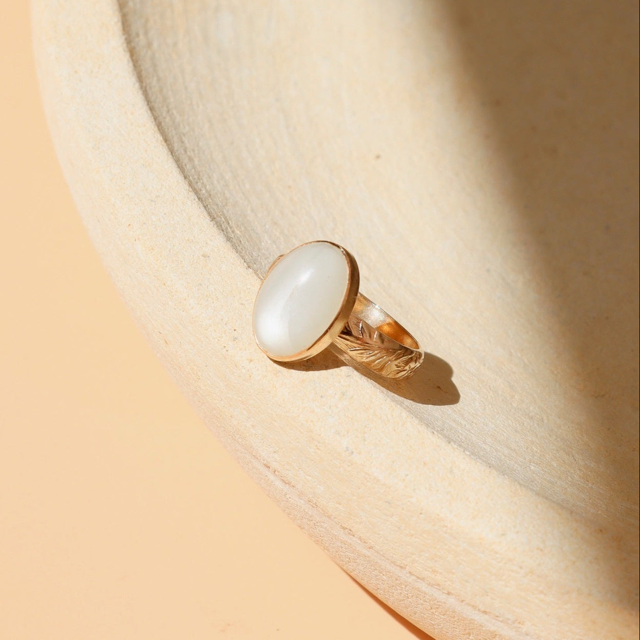 14k gold fill ring with oval moonstone  on a light dish
