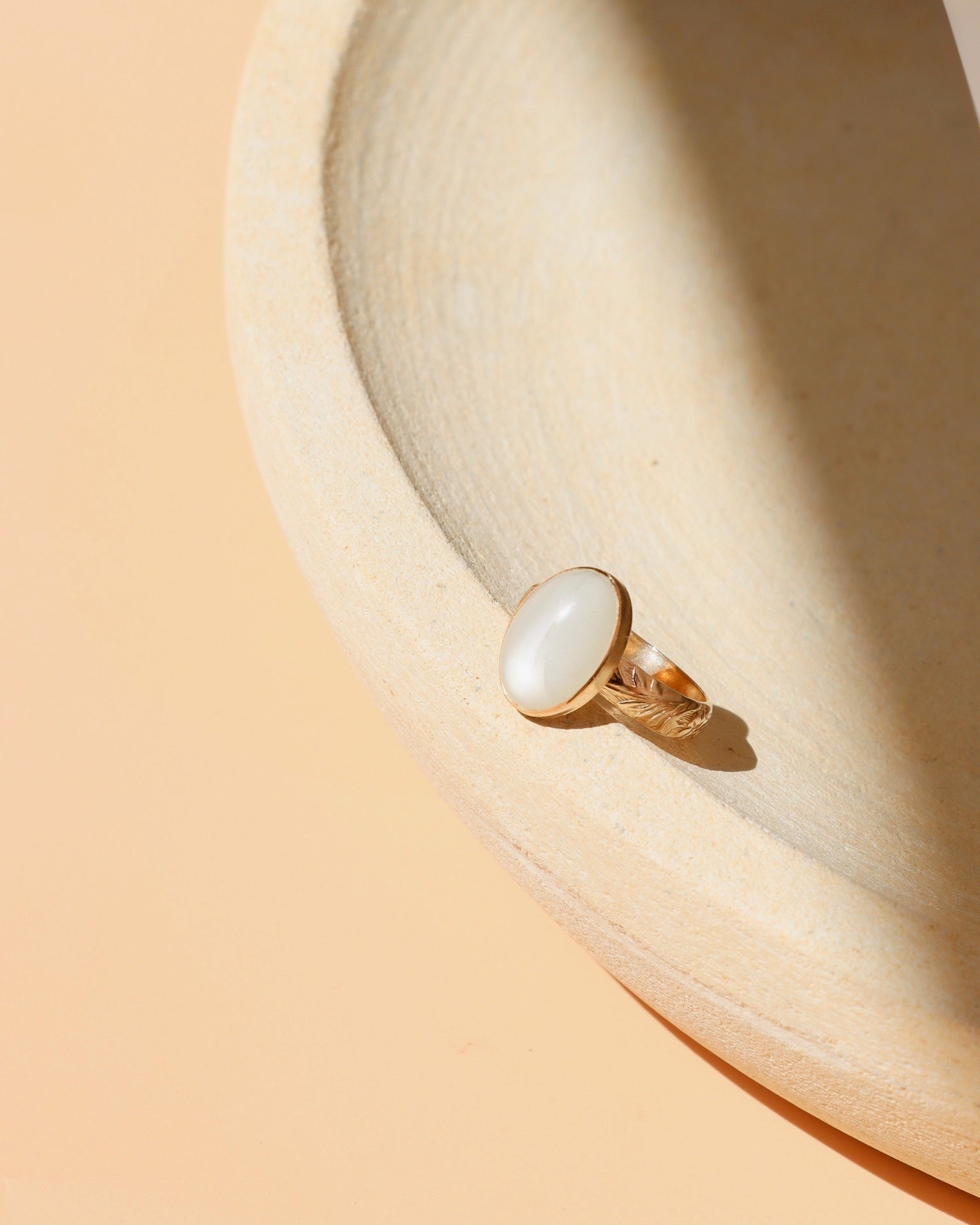 14k gold fill ring with oval moonstone  on a light dish