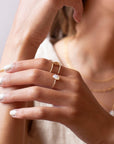 mother of pearl stone set in a bezel on a 14k gold fill skinny ring band, photographed on a model's hand