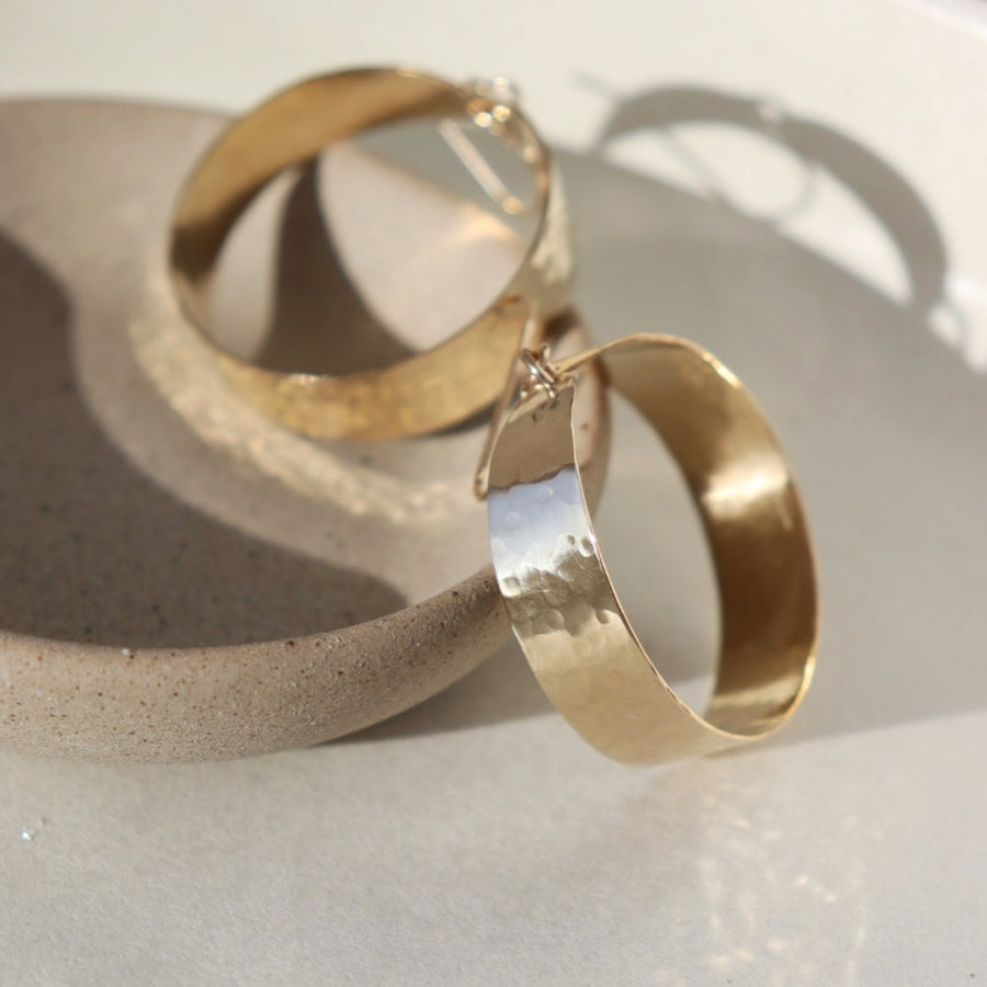 14k gold fill hammered hoops laid on a gray plate set in the sunlight, thick shiny hammered hoops, 14k Gold Filled, Sterling Silver, Eau Claire Wi, Handmade
