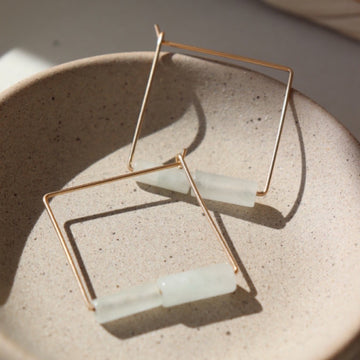 Gold Filled Square Hoops made with wire and embellished with Burma Jade Gemstones and sitting on a jewelry dish