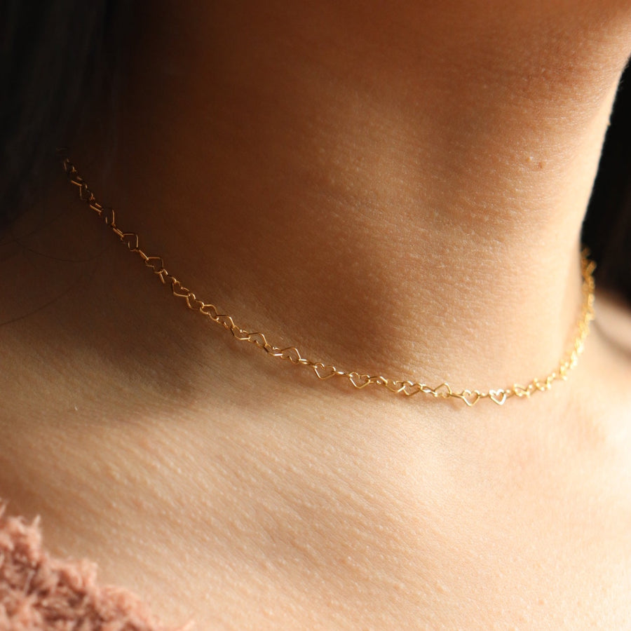 delicate gold fill heart chain necklace, photographed on a brunette model